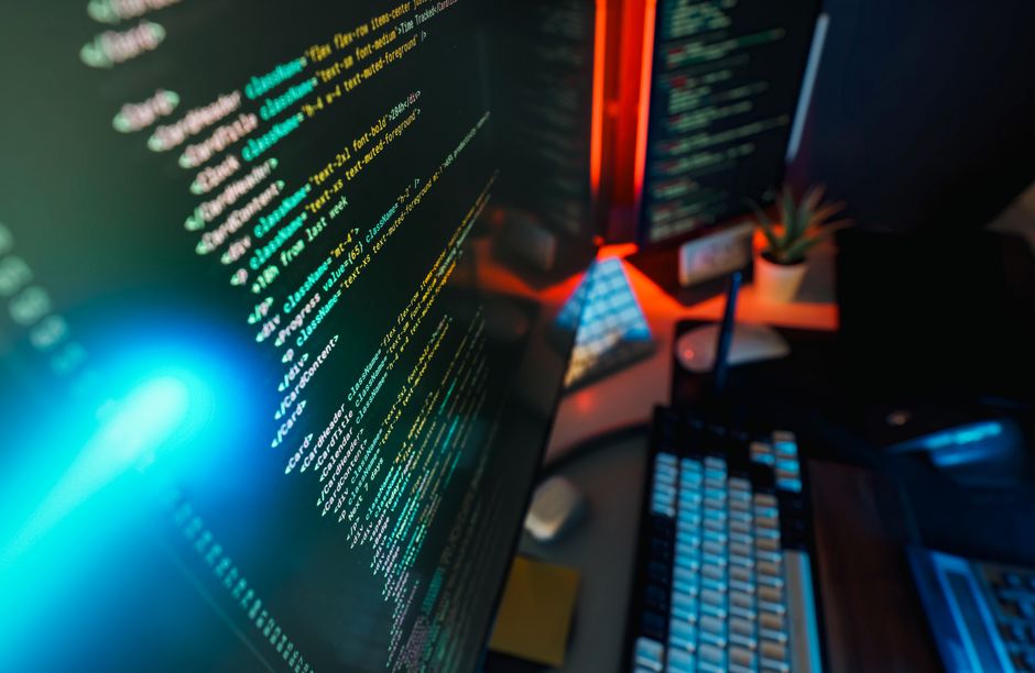 Futuristički radni prostor s ekranom na kojem je prikazan programski kod